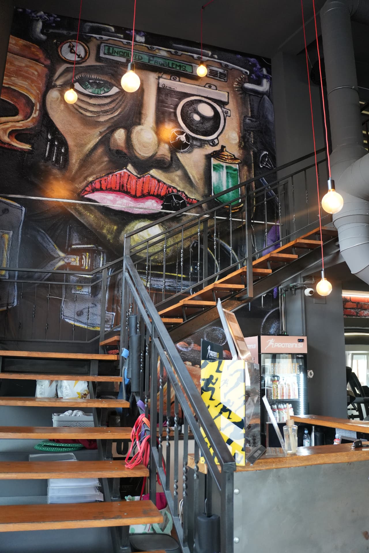 Unutrašnjost OUT FIT fitness centra u Samoboru sa stepenicama i zidnom mural grafikom